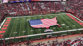 Large flag on the field at a Huskers football game
